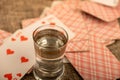 Playing cards and a glass of vodka on a table covered with coarse burlap Royalty Free Stock Photo