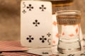 Playing cards and a glass of vodka on a table covered with coarse burlap Royalty Free Stock Photo