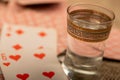 Playing cards and a glass of vodka on a table covered with coarse burlap Royalty Free Stock Photo