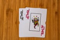 Playing cards joker card close up, isolated on wooden table. Casino concept, risk, chance, good luck or gambling Royalty Free Stock Photo