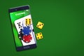 Playing cards, poker chips, and dice, on the smartphone screen. Green background. copy space. Online casino concept Royalty Free Stock Photo