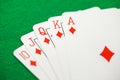 Playing cards, poker combination straight flush red diamond suit from ten to ace, on green background, selective focus