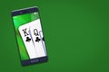 Playing cards on the smartphone screen. Green background. copy space. Online casino concept. Gambling. Royalty Free Stock Photo