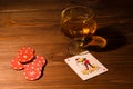 Playing cards and wine glass of cognac on wood table Royalty Free Stock Photo