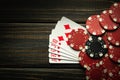 Playing cards with a winning combination of royal flush and chips on a black vintage table in a poker club. Free copy space for Royalty Free Stock Photo