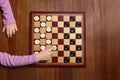 Playing checkers. Child thinking about next move at wooden table, top view Royalty Free Stock Photo