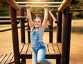 Playing is a childs favourite way of learning. a little girl playing on the jungle gym at the park. Royalty Free Stock Photo