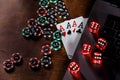 Playing chips, red dices, cards with aces and laptop on a wooden background Royalty Free Stock Photo