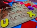 playing colorful wooden letter puzzles