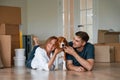 Playing with dog. Young couple is moving to new home Royalty Free Stock Photo