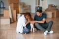 Playing with dog. Young couple is moving to new home Royalty Free Stock Photo