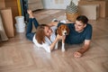 Playing with dog. Young couple is moving to new home Royalty Free Stock Photo