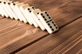 Playing dominoes on a wooden table. Domino effect Royalty Free Stock Photo