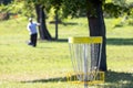 Playing flying disc golf sport game in the park, target basket in focus Royalty Free Stock Photo