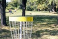 Playing flying disc golf sport game in the park, target basket in focus Royalty Free Stock Photo