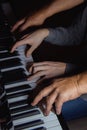 Playing four male hands on the piano. palms lie on the keys and play the keyboard instrument in a music school. student learns to Royalty Free Stock Photo