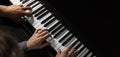 Playing four male hands on the piano. palms lie on the keys and play the keyboard instrument in a music school. student learns to