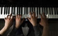 Playing four male hands on the piano. palms lie on the keys and play the keyboard instrument in a music school. student learns to Royalty Free Stock Photo