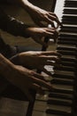 Playing four male hands on the piano. palms lie on the keys and play the keyboard instrument in a music school. student learns to