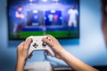 Video gaming and game play on tv fun gamer holding game-pad and controller video console playing and enjoying with blurred screen Royalty Free Stock Photo