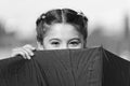 Playing hide and seek. Funny young girl hiding from somebody. Beautiful bright eyes. Girl with umbrella playing game Royalty Free Stock Photo