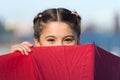 Playing hide and seek. Funny young girl hiding from somebody. Beautiful bright eyes. Girl with umbrella playing game Royalty Free Stock Photo