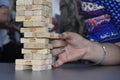 Playing jenga .Close up shot of female Male hand playing wooden blocks tower game .Wood blocks stack game Royalty Free Stock Photo