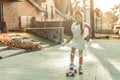 Resolute young lady in white dress riding on a skateboard Royalty Free Stock Photo