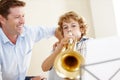 Playing, music sheet and father and child with trumpet for practice, lesson and skills for talent show. Family, creative Royalty Free Stock Photo