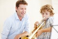 Playing, music and teacher and child with trumpet for practice, lesson and skills for talent show. Learn, creative hobby Royalty Free Stock Photo