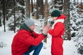 After playing in the open air in the winter in the woods, the boy`s hands froze and his father sat down in front of him Royalty Free Stock Photo