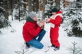 After playing in the open air in the winter in the woods, the boy`s hands froze and his father sat down in front of him Royalty Free Stock Photo