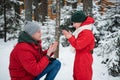 After playing in the open air in the winter in the woods, the boy`s hands froze and his father sat down in front of him Royalty Free Stock Photo