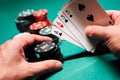 Playing poker in the casino. Cards with two pairs in the hand of the player making a bet with chips