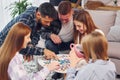 Playing puzzle game. Group of friends have party indoors together Royalty Free Stock Photo