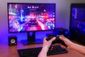 Playing racing games on computer concept. Hand holds the joystick