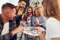 Playing smart game. Group of friends have party indoors together Royalty Free Stock Photo