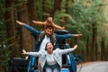 Playing together. Mother, father and little son are waiting for electric car to charge outdoors Royalty Free Stock Photo