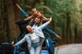 Playing together. Mother, father and little son are waiting for electric car to charge outdoors Royalty Free Stock Photo