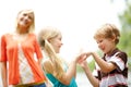 Playing together while relaxing with mom. Two cute young children spending time outdoors with their mother. Royalty Free Stock Photo