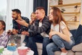 Playing video game. Group of friends have party indoors together Royalty Free Stock Photo