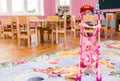 Playroom in kindergarten. In the foreground sits a doll in a pink stroller