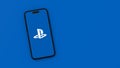 Playstation Logo on Mobile Phone Screen on Blue Background with Copy Space Royalty Free Stock Photo