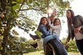 Playtime is a family affair. a happy mother and father pushing their daughters on a tyre swing. Royalty Free Stock Photo