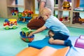 Playtime at nursery school. Toddlers sitting on the floor and playing with colorful plastic cars, boats and other toys. Royalty Free Stock Photo