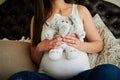 Playtime starts before her due date. an unidentifiable pregnant woman holding a stuffed toy while sitting on her bed at Royalty Free Stock Photo