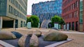 Plaza with stone sculpture between three modern style office buildings in Prague\'s Karlin district