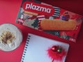 Plazma biscuit with plazma shake and notebook with new year decoration pencil on red background