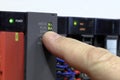 PLC - Programmable logic controller. LED indicators. The hand shows the operation of the system. Program run. Production Royalty Free Stock Photo