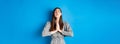 Pleading woman in dress begging for wish come true, supplicating god, standing against blue background Royalty Free Stock Photo